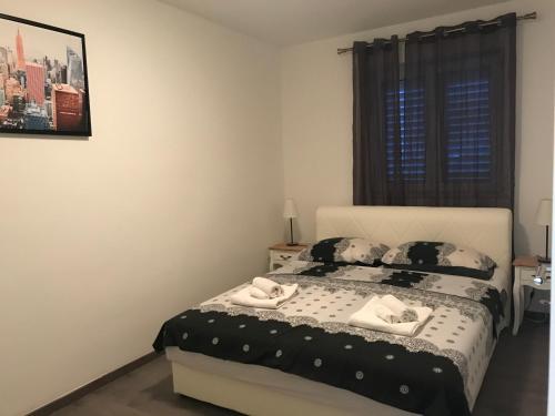 a bedroom with a bed with two towels on it at Apartments M&E in Mokošica