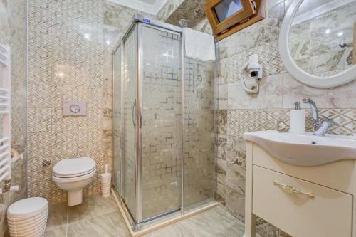 a bathroom with a shower and a toilet and a sink at Cunda Özerbey Konağı in Ayvalık