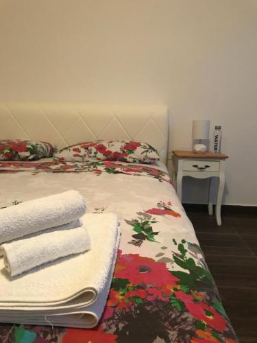 a bedroom with a bed with towels on it at Apartments M&E in Mokošica