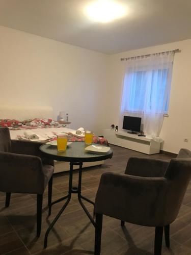 a living room with a table and chairs and a bed at Apartments M&E in Mokošica