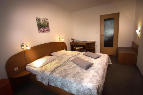 1 dormitorio con 1 cama con 2 almohadas en B&B Brezov Gaj, en Kranjska Gora