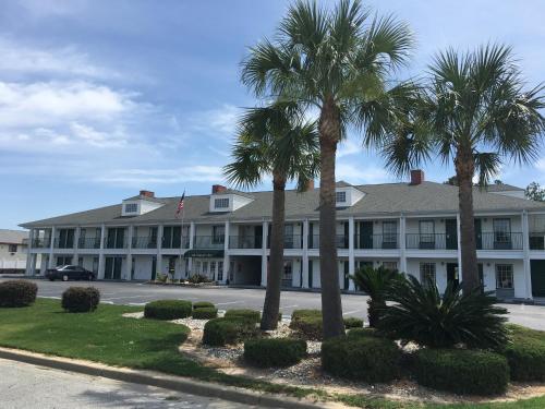 a large white building with palm trees in front of it at Jameson Inn Douglas in Douglas