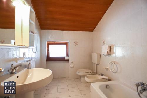 フォルガリーアにあるChalet Lailaのバスルーム(洗面台、トイレ、バスタブ付)
