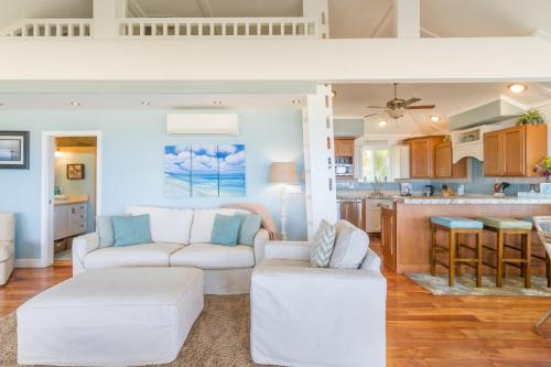 un soggiorno con mobili bianchi e una cucina di Pipe Beach House a Pupukea