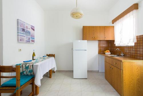 a kitchen with a white refrigerator and a table at Annabel Apartments in Theologos