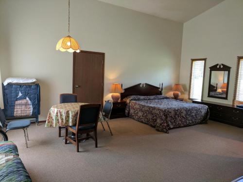 a bedroom with two beds and a table and chairs at Rock Creek Mercantile & Motel in Clinton