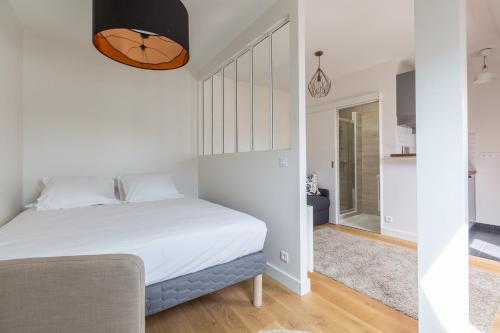 - une petite chambre avec un lit et un couloir dans l'établissement Assas-Vavin Appartements, à Paris
