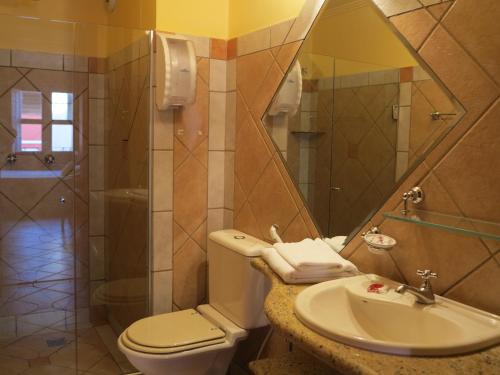 a bathroom with a toilet and a sink and a mirror at Pousada do Pilar in Salvador