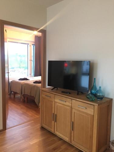 a living room with a flat screen tv on a wooden cabinet at The Harbour Apartments in Jyväskylä