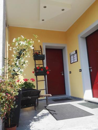 a front door of a house with flowers and a ladder at B&B Guglielmina in Quarna Sotto