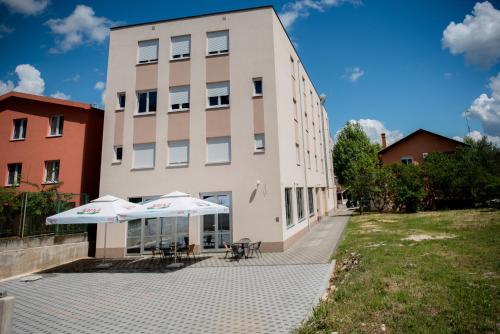 a building with two umbrellas in front of it at Hotel Martin in Međugorje