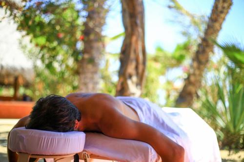 a man is laying in a chair in a chair at Cerritos Surf Town - Beach Front Property in El Pescadero