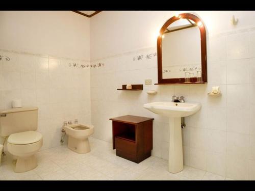 a bathroom with a toilet and a sink and a mirror at Lands in Love Hotel and Resort in Colonia Palmareña