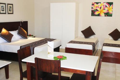a hotel room with two beds and two tables at Smugglers Cove Beach Resort & Hotel in Nadi
