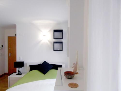 リスボンにあるAlfama 2 Youのベッドルーム1室(ベッド1台、壁に照明付)