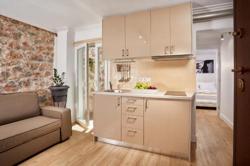 una cocina con armarios blancos y un sofá en una habitación en warm stone house en Athens
