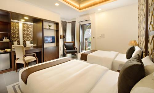 a hotel room with two beds and a desk at Mithi Resort & Spa in Panglao