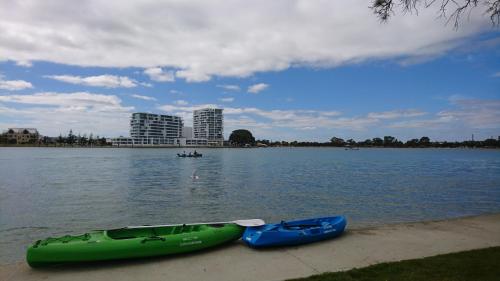 Mandurah Coastal Holiday Park في ماندورا: وجود زورقين على شاطئ البحيرة