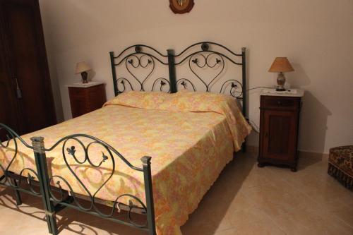 a bedroom with a bed and a wooden night stand at Casa Assuntina in Acaya