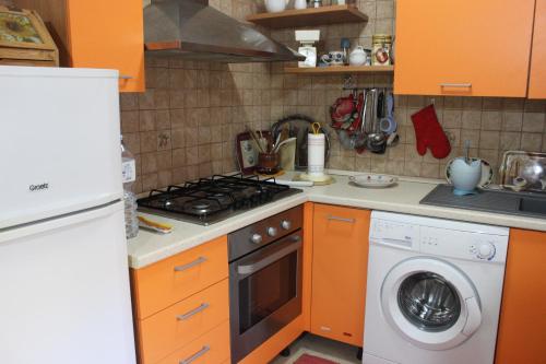 アカイアにあるCasa Assuntinaのキッチン(オレンジ色のキャビネット、洗濯機付)
