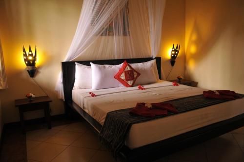 a hotel room with a bed and a lamp at Tirta Sari Bungalow in Pemuteran