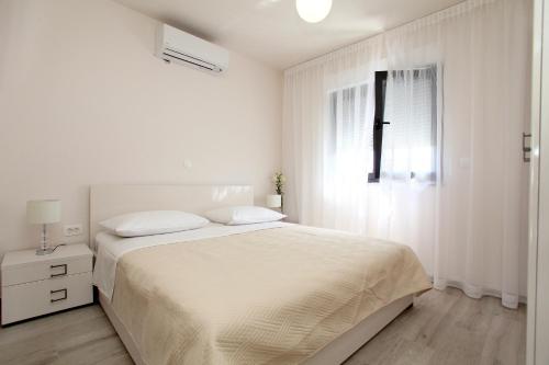 A bed or beds in a room at Apartments Villa Aquamarie