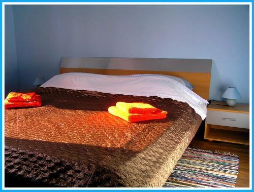 uma cama com duas toalhas vermelhas e amarelas em Apartmani Andrija em Jezera
