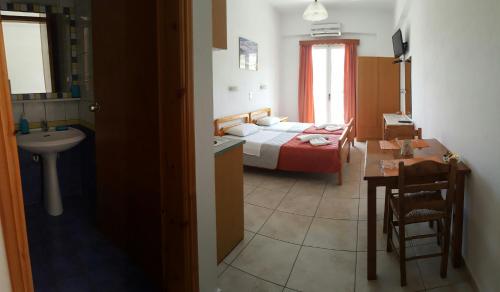 a bedroom with a bed and a bathroom with a sink at Sofia Studios & Apartments in Georgioupolis