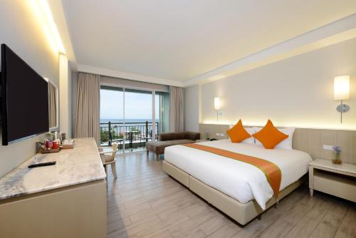 a hotel room with a large bed and a television at Hisea Huahin Hotel in Hua Hin