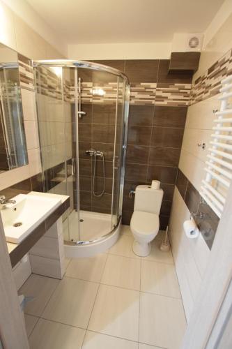 a bathroom with a shower and a toilet and a sink at Kalmar in Darlowko