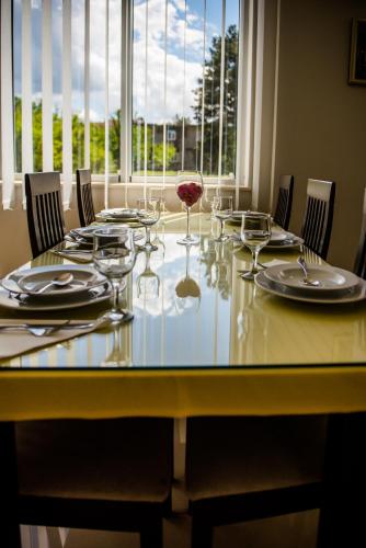 a dining table with glasses and plates and chairs at Hotel Martin in Međugorje