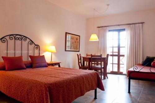 a bedroom with a bed and a dining room at Leyenda Posada in Capilla del Monte