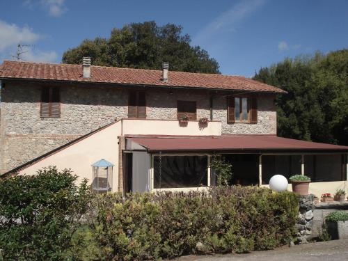 a large stone house with a red awning at Locanda il Boschetto in Volterra