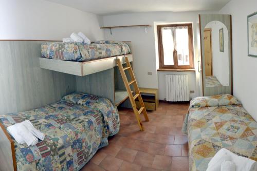 a room with two beds and a bunk bed at Valdigiust in Campodolcino