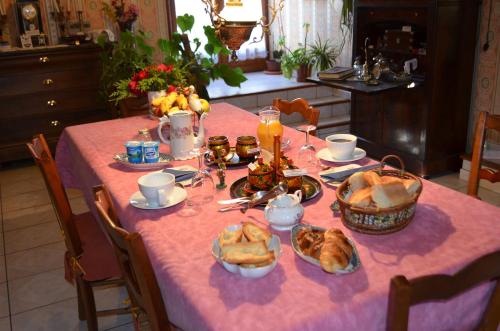 een tafel met een roze tafelkleed met voedsel erop bij Maison d'Autrefois in Mareau-aux-Prés