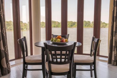 a table with a bowl of fruit in front of a window at Prestige Hotel in Belene