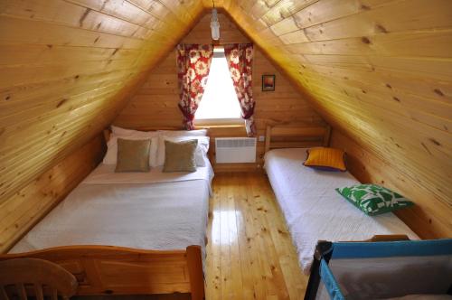 a bedroom with two beds in a log cabin at Chalet Escapade with Sauna in Žabljak