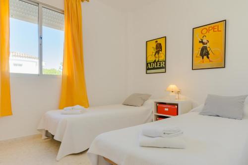 a room with two beds and a poster on the wall at Duplex El Manantial in El Puerto de Santa María