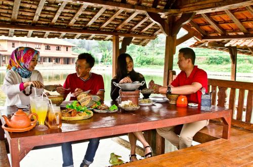 a group of people sitting around a table eating food at Puri Sakanti Nature Family Resort in Ciwidey