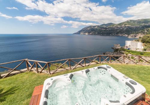 a bath tub sitting on top of a field next to the ocean at Villa Anna in Maiori