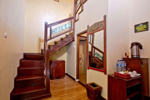 a hallway with a spiral staircase in a house at Puri Sakanti Nature Family Resort in Ciwidey