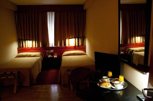 a hotel room with two beds and a table with food on it at Anaco in Madrid