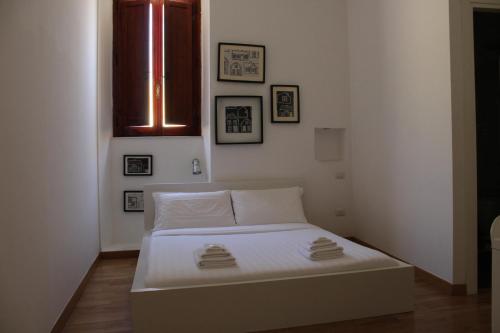 a small bedroom with a white bed and a window at I'MC IoAMoCagliari in Cagliari