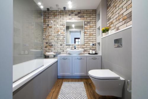 a bathroom with a white toilet and a sink at Marine Rooms in Kazimierz Dolny