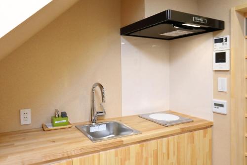 a kitchen with a sink and a stove at 京一軒町家 染 SEN 大宮五条 Omiya-Gojo in Kyoto