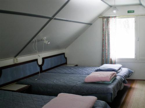a bedroom with two beds and a window at Lomakoivulehto in Saarijärvi