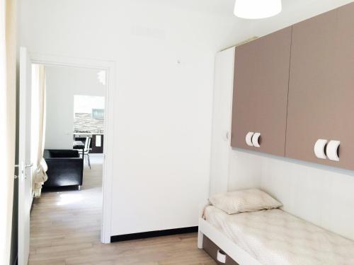 ein kleines Schlafzimmer mit einem Bett und einem Spiegel in der Unterkunft Miramare Apartment Genova in Genua