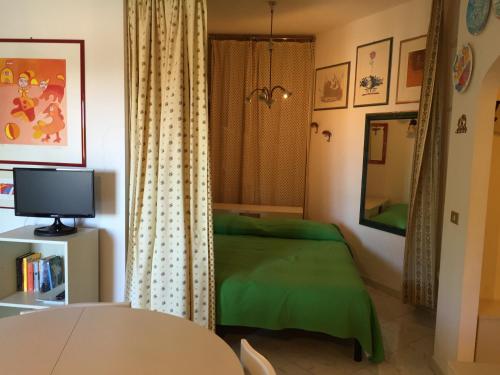 マリーナ・ディ・カスタニェート・カルドゥッチにあるBlue Suiteのベッドルーム(緑のベッド1台、テーブル付)