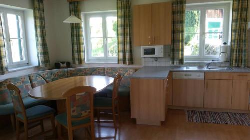 a kitchen with a table and a table and chairs at Steirer Haus in Gamlitz