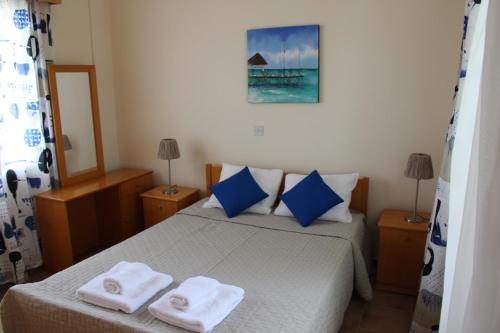 a bedroom with a bed with two towels on it at Zenovia Garden House in Pissouri